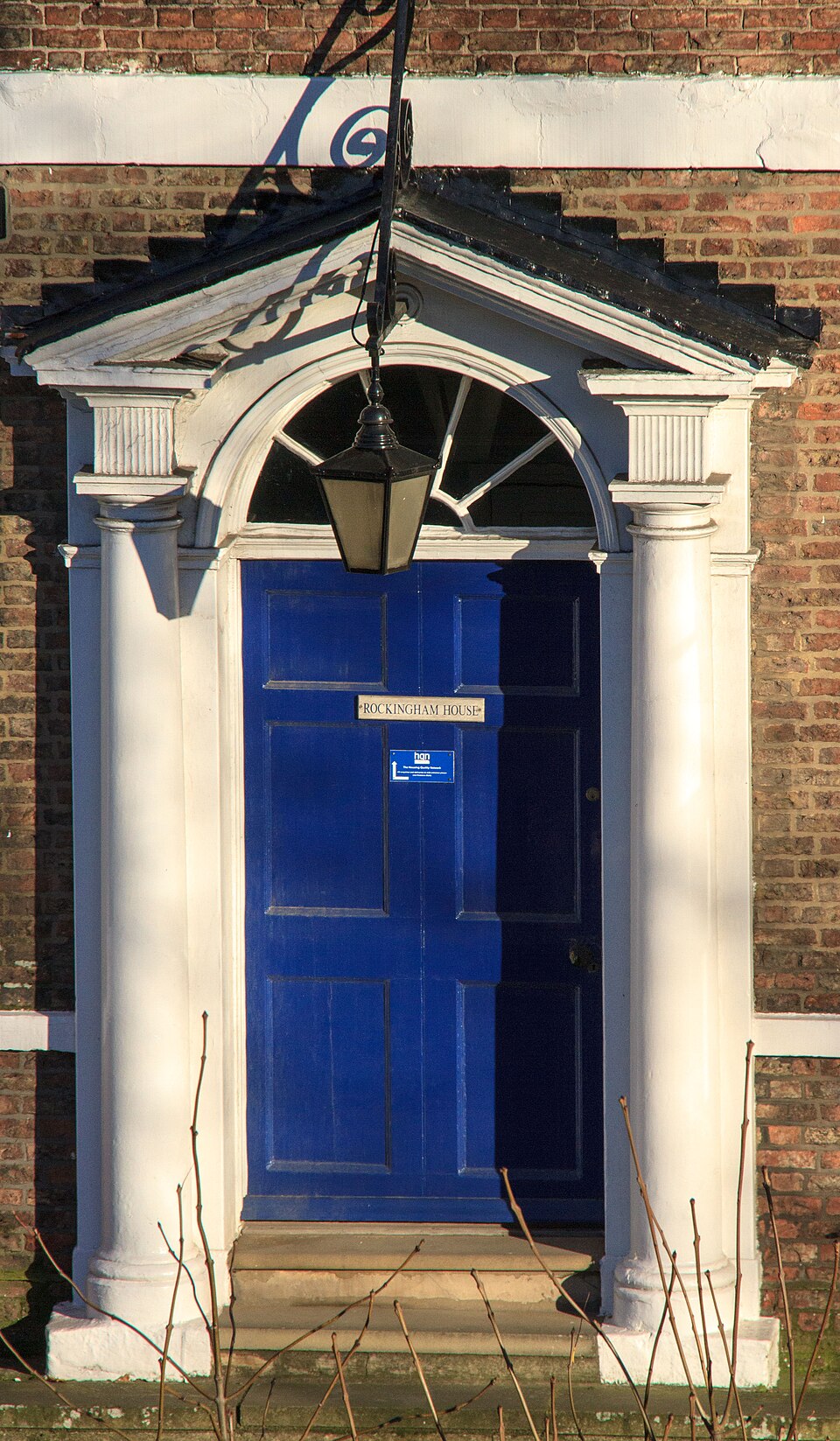 Deep blue paneled door beneath a decorative stone entrance surround.