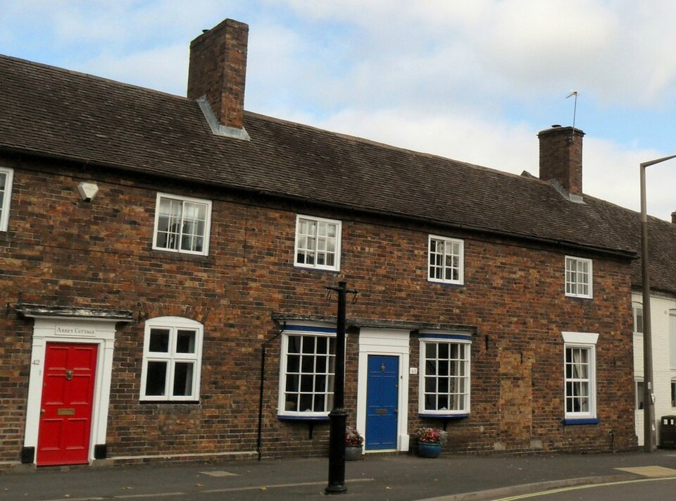 Red and blue doors punctuate adjacent brick cottages.