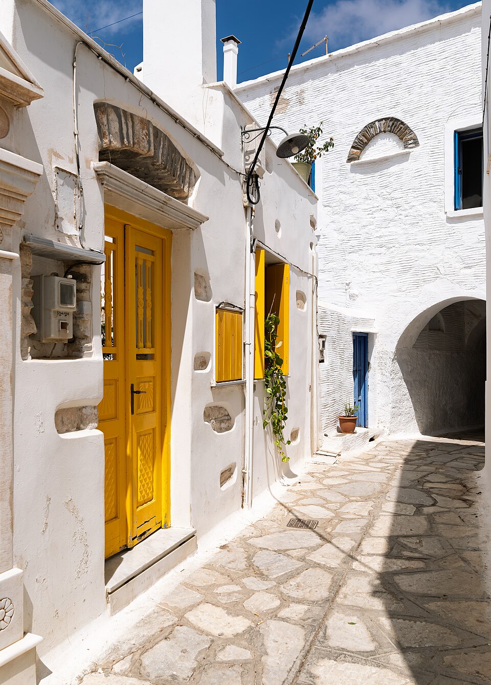 Yellow door and window in a narrow whitewashed street on Tinos, Greece.