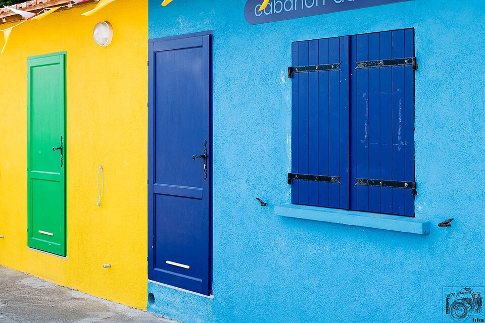 Blue and green doors against brightly painted yellow and blue walls.